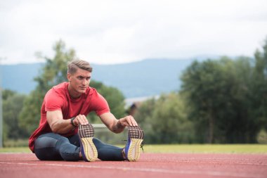 mâle coureur étirement avant l'entraînement