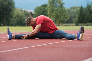 mâle coureur étirement avant l'entraînement