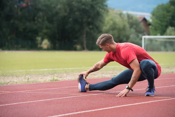 Corredor masculino estirándose antes del entrenamiento —  Fotos de Stock