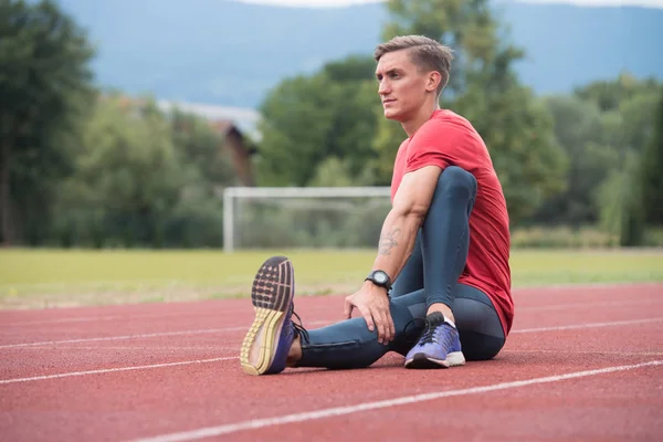 Knappe Man die zich uitstrekt voordat u gaat trainen buiten lopen — Stockfoto