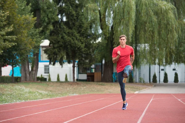 Junge männliche Athletin läuft auf der Bahn — Stockfoto