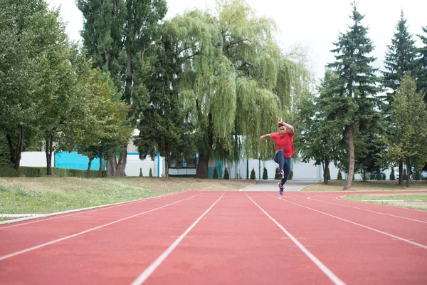 Junge männliche Athletin läuft auf der Bahn — Stockfoto