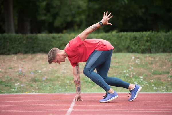 Sprinter verlässt Startblöcke auf der Laufstrecke — Stockfoto