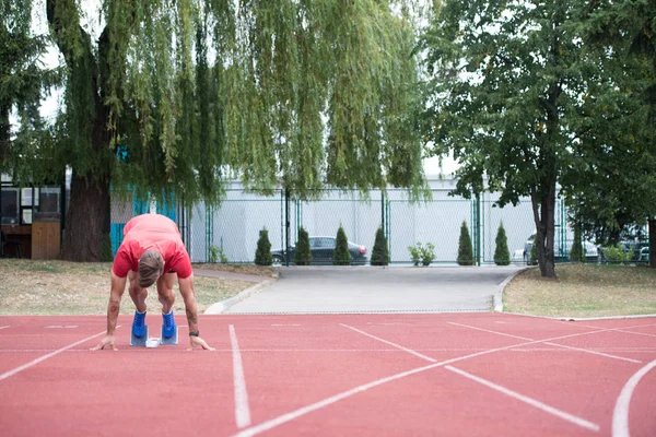 Masculino Sprinter chegando pronto para iniciar a corrida — Fotografia de Stock