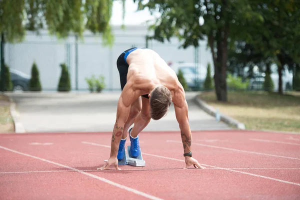 Sprinter verlässt Startblöcke auf der Laufstrecke — Stockfoto