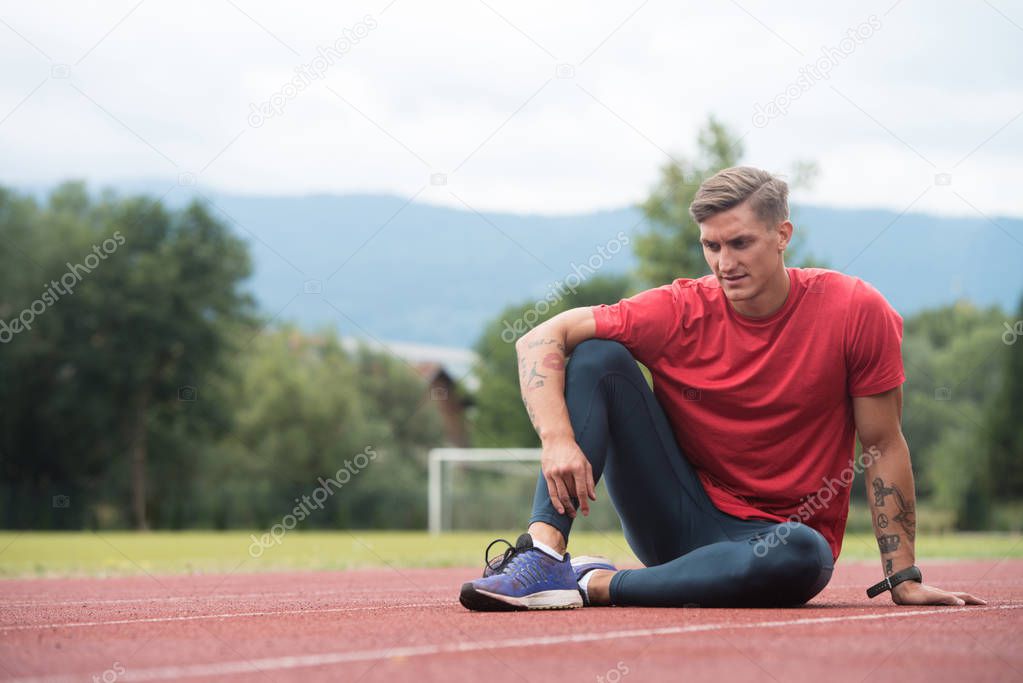 Young Athletic Man Stretching Before Running Exercise
