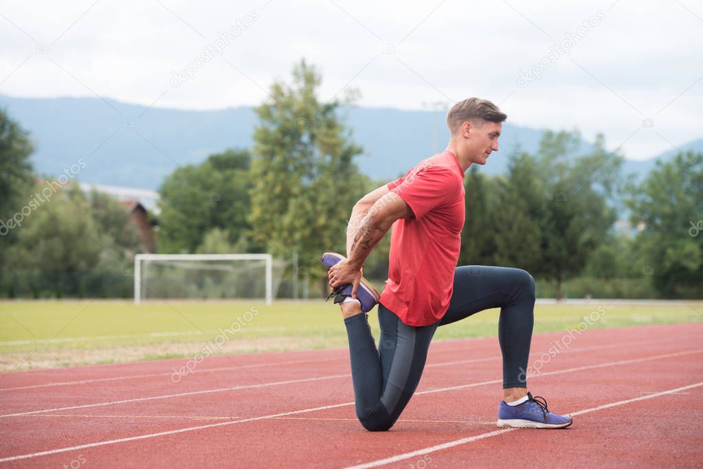 Fitness Man Stretching Before Workout Running on Track