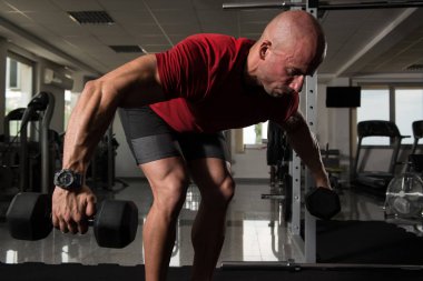 Kaslı adam arka için ağır egzersiz yaparak