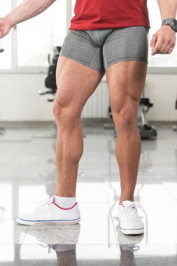Adam iyi eğitimli bacaklarını gösteren spor salonunda
