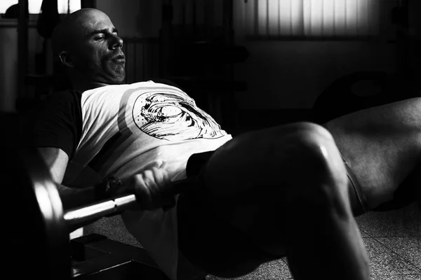 Hombre con barra ejercitando cuádriceps y glúteos —  Fotos de Stock