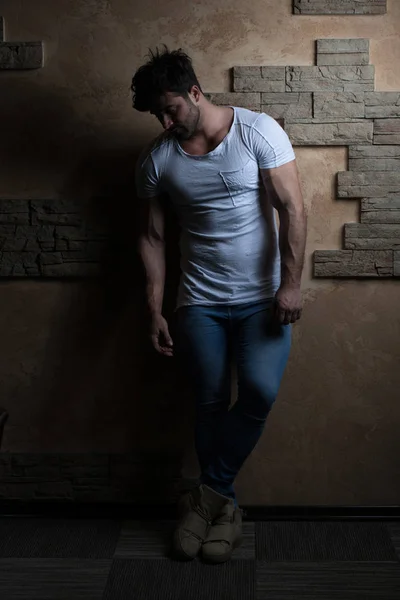 Model Flexing Muscles Against a Brick Wall — Stock Photo, Image