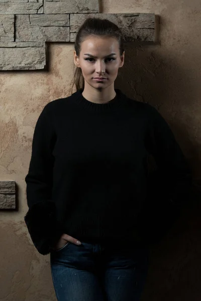 Kobieta stojąc przed mur z cegły — Zdjęcie stockowe