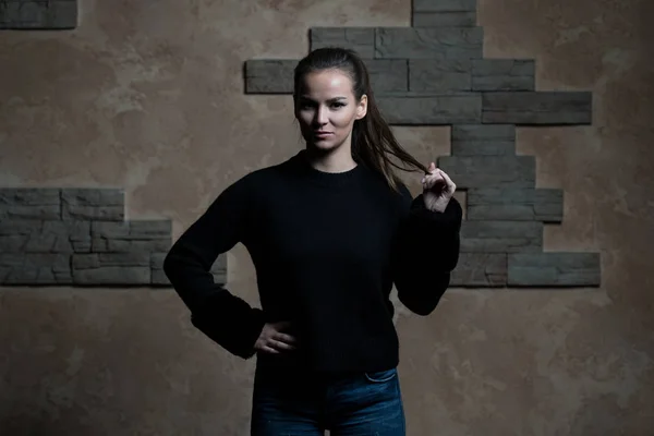 Mooie jonge vrouw leunend tegen een stenen muur — Stockfoto
