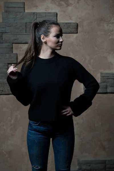Женщина, стоящая у кирпичной стены — стоковое фото