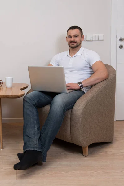 Hombre Guapo Sentado Mesa Sala Estar Usando Ordenador Portátil Casa — Foto de Stock