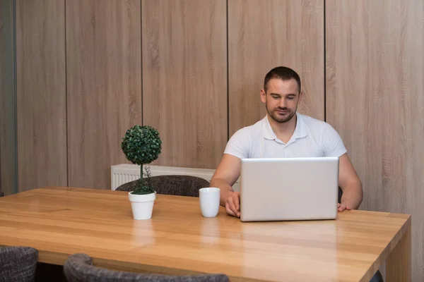 Schöner Mann Sitzt Wohnzimmertisch Mit Laptop Computer Hause — Stockfoto