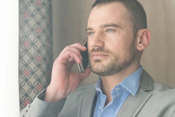 Mutlu Genç Adamı Modern Oturma Odasında Çalışıyor Telefonda Konuşuyor — Stok fotoğraf