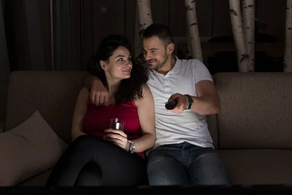 年轻异性恋夫妇拥抱在沙发上 看电影在电视上的在家里 — 图库照片