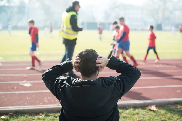 Прихильник Чоловік спостерігає за футбольною грою на відкритому повітрі сидячи — стокове фото