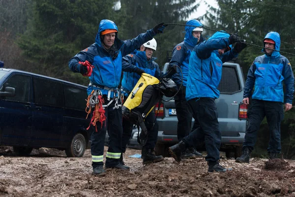 Rescate hombre ayudando a cabo en la tierra con cuerda — Foto de Stock