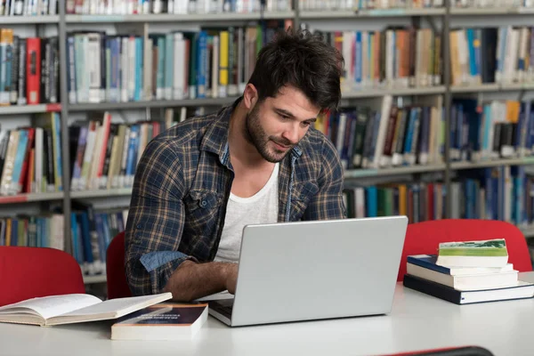 Student med sin Laptop i ett bibliotek — Stockfoto