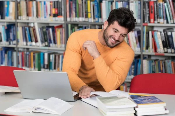 快乐的男学生在图书馆中的笔记本电脑 — 图库照片