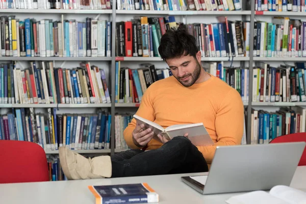 Bello studente universitario in una biblioteca — Foto Stock