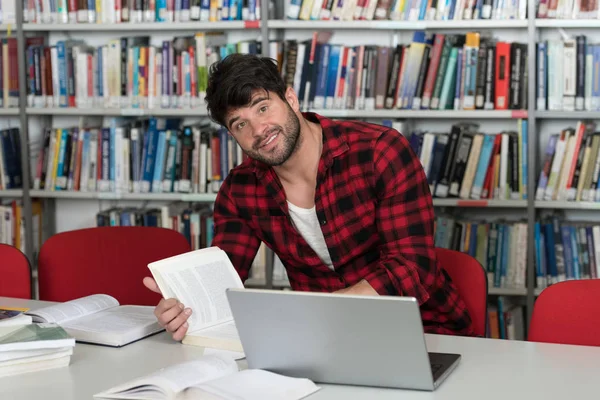 Student zijn Laptop gebruikt in een bibliotheek — Stockfoto