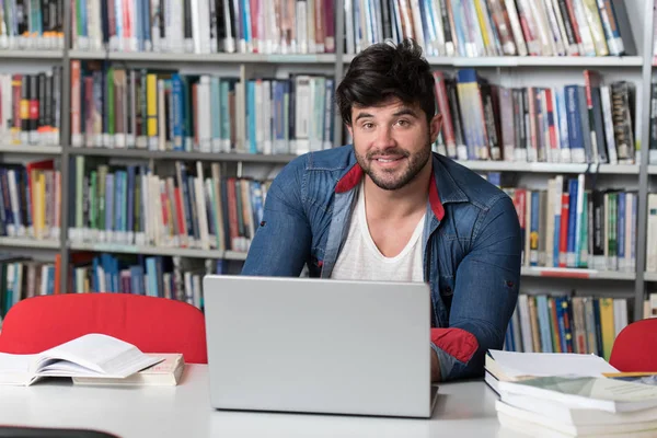 Щасливий Чоловік Студент з ноутбуком в бібліотеці — стокове фото