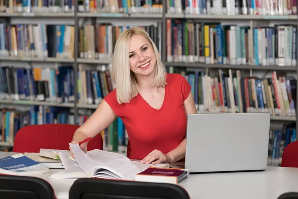 Mujer rubia feliz trabajando en la biblioteca —  Fotos de Stock