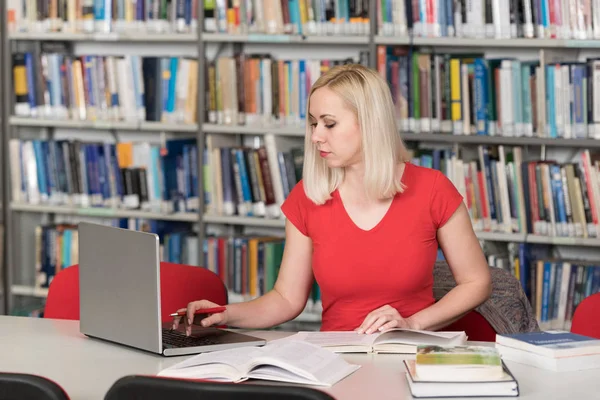 女子学生が大学の図書館でのラップトップの入力 — ストック写真