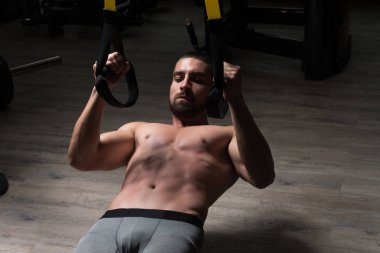 Trx Fitness askıları ile genç çekici adam eğitim