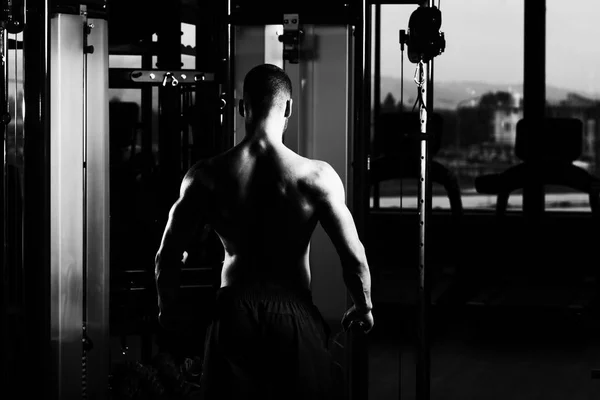 Homem muscular flexionando músculos no ginásio — Fotografia de Stock