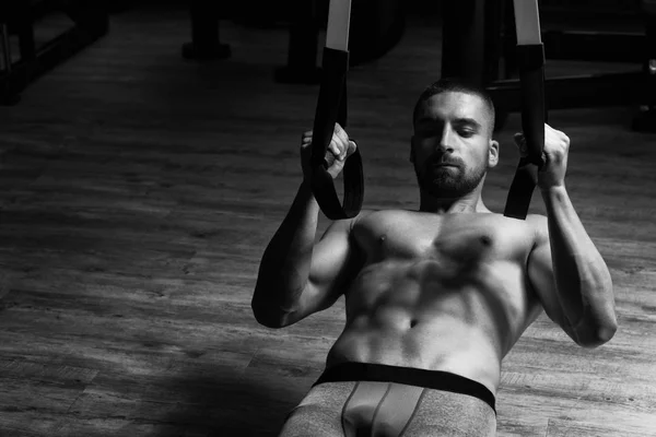Giovane attraente uomo formazione con cinghie di fitness Trx — Foto Stock