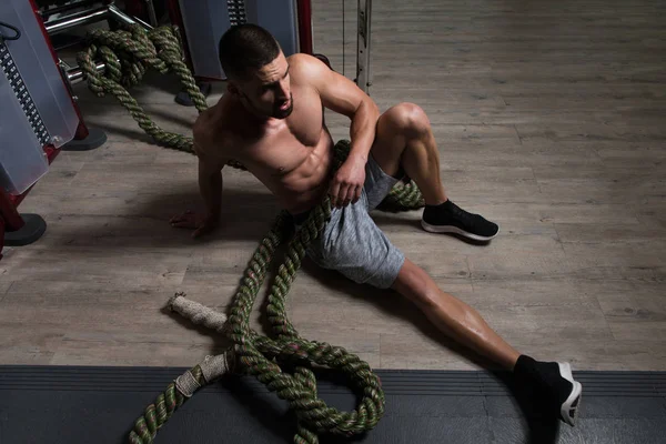 Joven descansando después de batallar cuerdas en el gimnasio — Foto de Stock