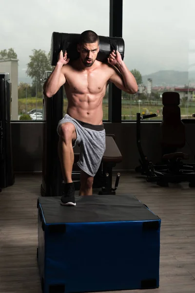 Jeune homme en forme faisant des sauts de boîte dans la salle de gym — Photo