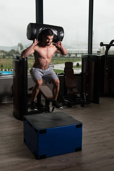 Jeune homme en forme faisant des sauts de boîte dans la salle de gym — Photo