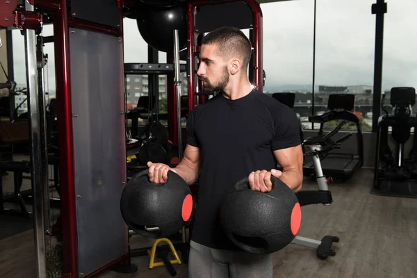 Biceps exercice avec des boules de médecine dans un gymnase — Photo