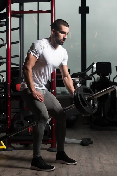 Muskulöser Mann trainiert Rücken mit Langhantel — Stockfoto