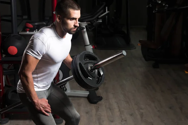 Muskulöser Mann trainiert Rücken mit Langhantel — Stockfoto
