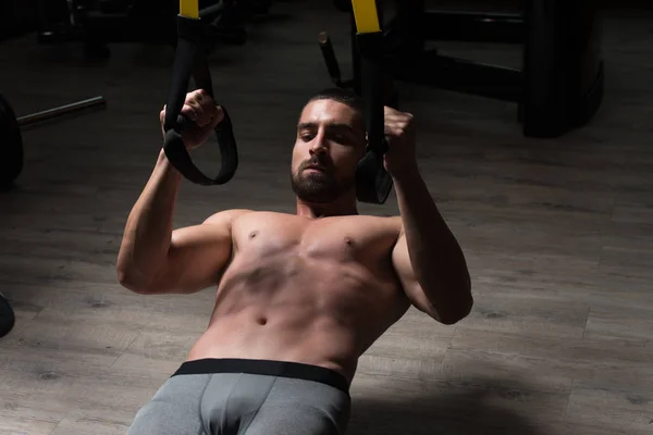 Trx Fitness askıları ile genç çekici adam eğitim — Stok fotoğraf