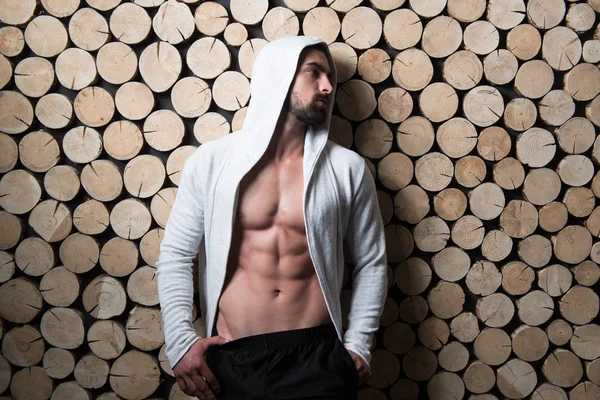 Model buigen spieren In Sweatshirt tegen de muur — Stockfoto