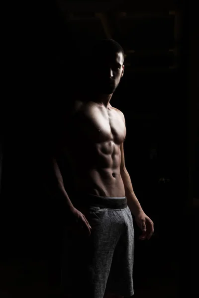 Retrato del hombre en forma en la habitación oscura — Foto de Stock