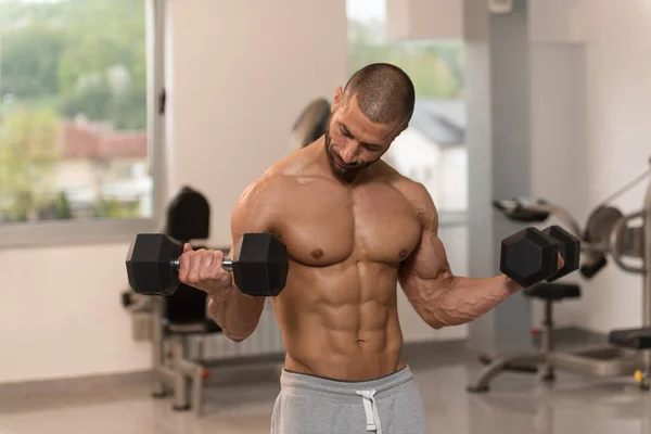 Kroppsbyggare tränar biceps med hantlar — Stockfoto