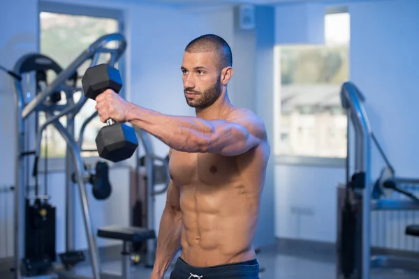 Bodybuilder trainiert Schultern mit Kurzhanteln — Stockfoto