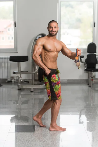 Mužské fitness konkurenta ukazující jeho vítězné medaile — Stock fotografie