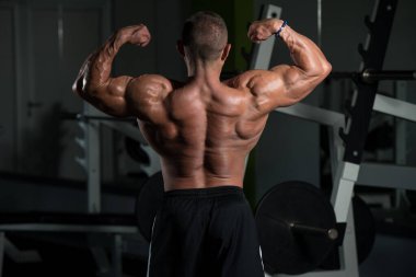 Olgun Vücut Geliştirici Egzersiz yaptıktan sonra pazılara poz veriyor