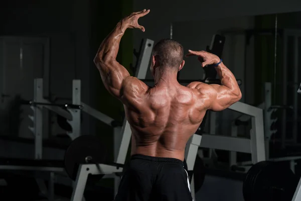 Rijpere bodybuilder poseren biceps na oefeningen — Stockfoto