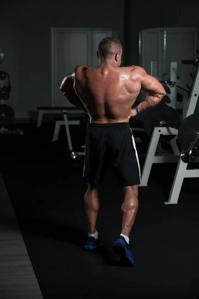 Muscular maduro hombre flexing músculos en gimnasio — Foto de Stock