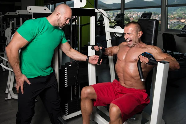 Gym Coach hjälpa man på bröstet — Stockfoto